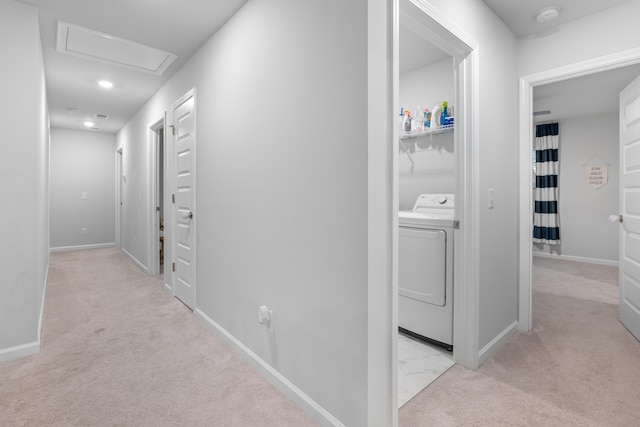 hallway featuring light colored carpet and washer / dryer