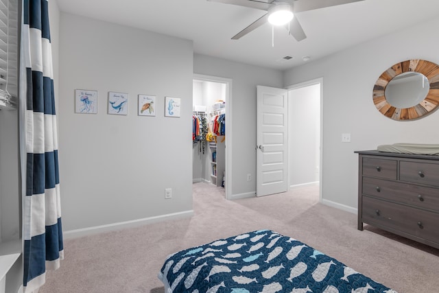 carpeted bedroom with a closet, ceiling fan, and a spacious closet