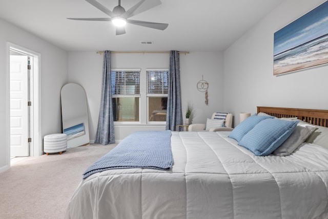 carpeted bedroom with ceiling fan and multiple windows