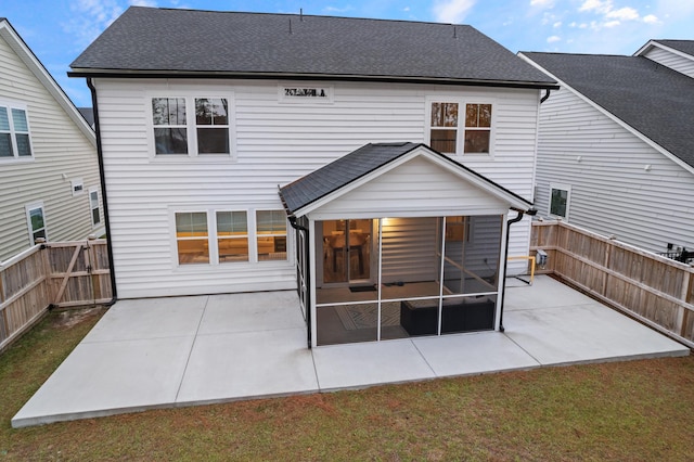 back of property featuring a yard, a sunroom, and a patio area