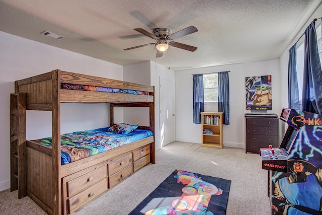 bedroom featuring carpet, a ceiling fan, a textured ceiling, and visible vents