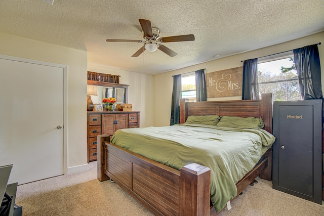 bedroom featuring a textured ceiling, ceiling fan, and light carpet