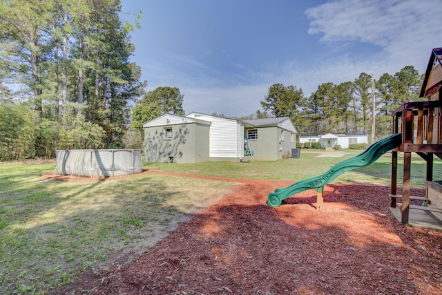 view of yard with a playground, an outdoor structure, and an outdoor pool