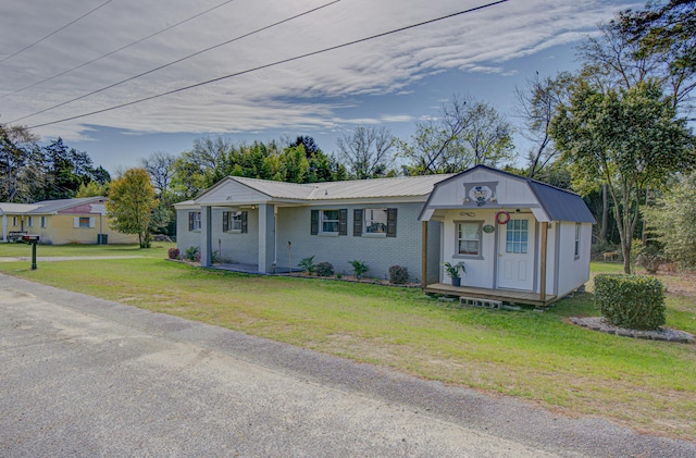 view of front of house with brick siding, metal roof, and a front lawn