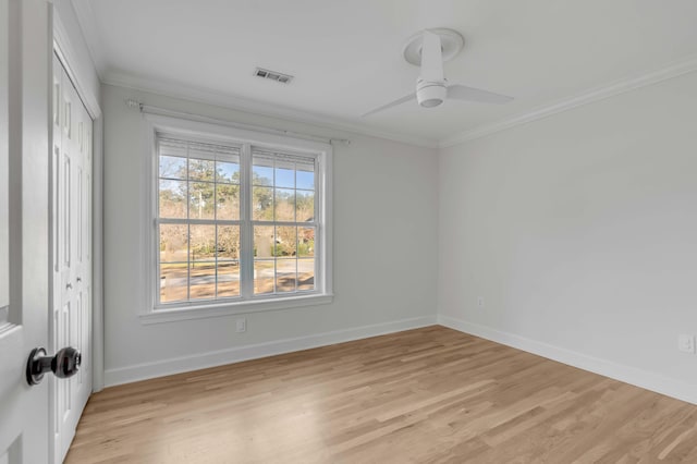 unfurnished room featuring light wood-type flooring, crown molding, and baseboards