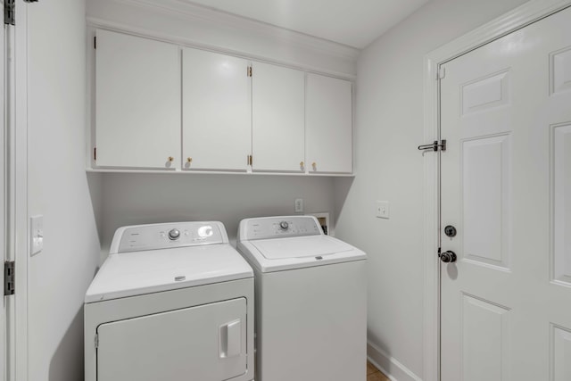 clothes washing area featuring cabinet space, baseboards, and independent washer and dryer