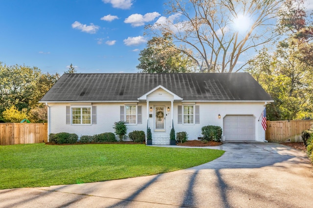 ranch-style home featuring a front yard, concrete driveway, brick siding, and fence