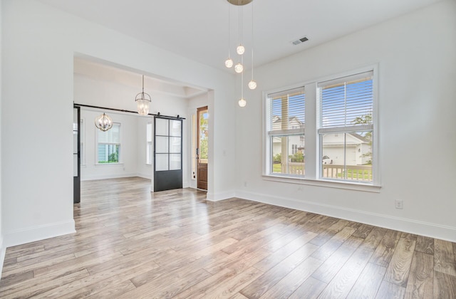 1485 Bourne Xing, Mount Pleasant, SC 29466 - empty room featuring light wood-type flooring, a barn door, and a chandelier