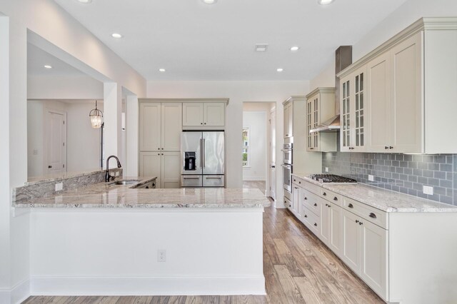 1485 Bourne Xing, Mount Pleasant, SC 29466 - kitchen featuring appliances with stainless steel finishes, light stone countertops, a peninsula, glass insert cabinets, and recessed lighting