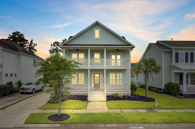 1485 Bourne Xing, Mount Pleasant, SC 29466 - view of front of home featuring board and batten siding, a balcony, covered porch, a front lawn, and concrete driveway