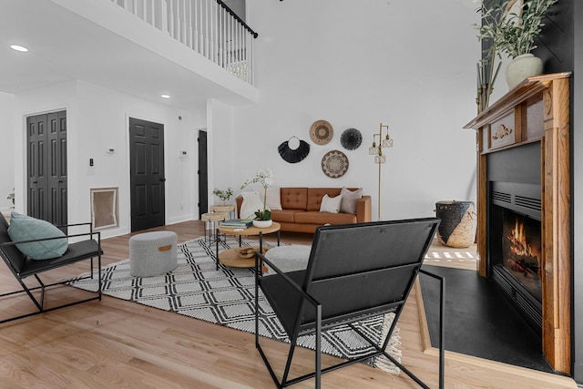 3385 Wayland Dr, Ladson, SC 29456 - living area with light wood-type flooring, a lit fireplace, a towering ceiling, and recessed lighting