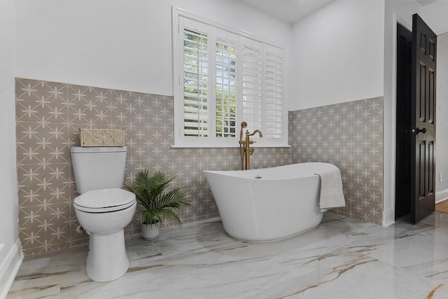 3385 Wayland Dr, Ladson, SC 29456 - bathroom featuring a soaking tub, a wainscoted wall, healthy amount of natural light, and tile walls