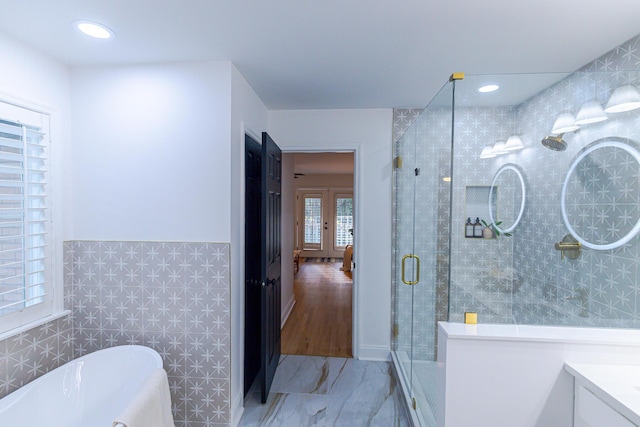 3385 Wayland Dr, Ladson, SC 29456 - bathroom with vanity, a freestanding tub, a shower stall, tile walls, and a wainscoted wall