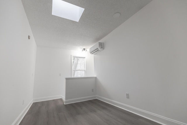 3385 Wayland Dr, Ladson, SC 29456 - empty room with an AC wall unit, a textured ceiling, dark wood-style floors, and a skylight