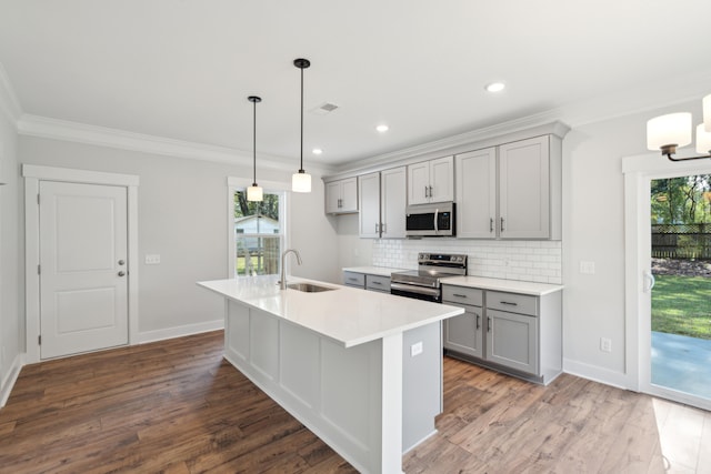 kitchen featuring sink, hanging light fixtures, crown molding, decorative backsplash, and appliances with stainless steel finishes