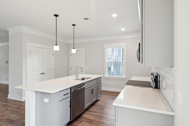 kitchen featuring decorative light fixtures, sink, stainless steel appliances, and a center island with sink