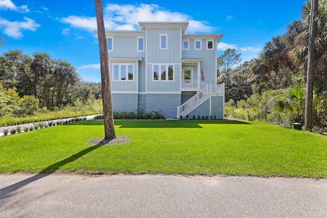 raised beach house featuring a front lawn