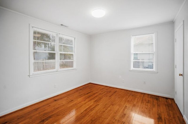 unfurnished room featuring wood-type flooring and ornamental molding