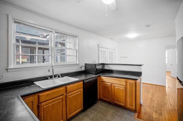 kitchen featuring dark tile patterned flooring, sink, and black appliances