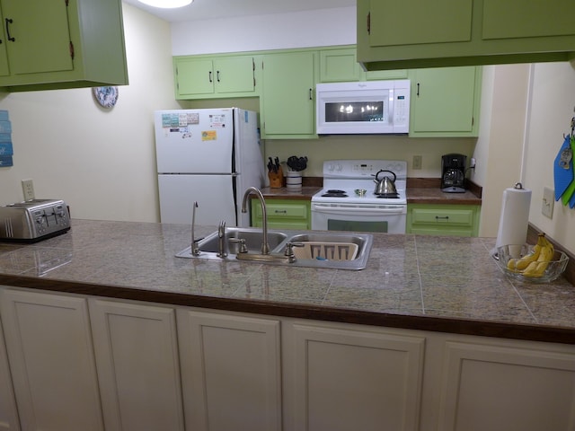 kitchen featuring white appliances, sink, and green cabinetry