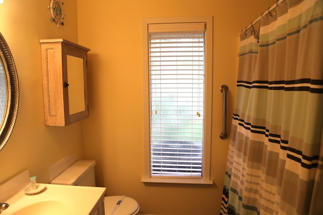 bathroom featuring vanity, a shower with curtain, toilet, and a wealth of natural light