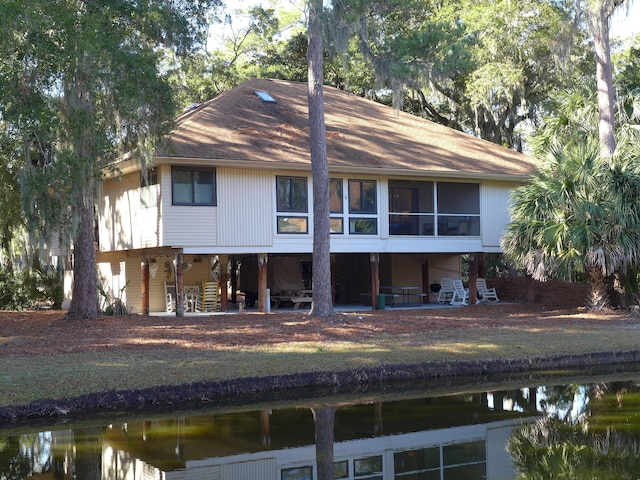 rear view of house featuring a sunroom and a water view