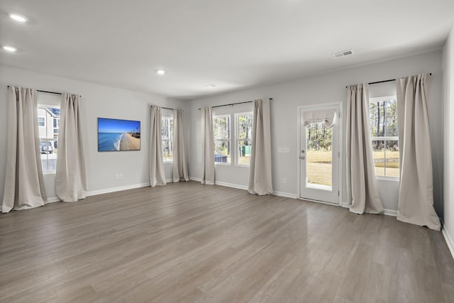 unfurnished room featuring a healthy amount of sunlight and light hardwood / wood-style floors