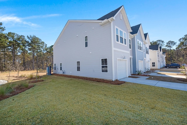 view of side of home with a garage and a lawn