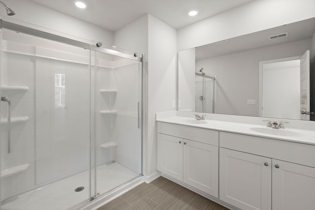 bathroom featuring vanity and a shower with door