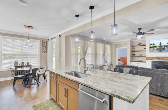 kitchen featuring dishwasher, pendant lighting, sink, and light hardwood / wood-style floors