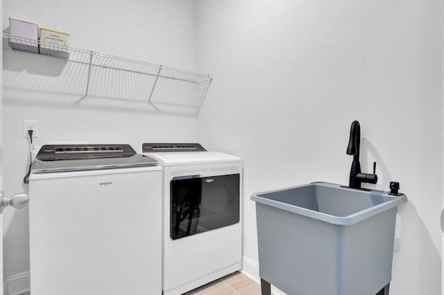 laundry area featuring light tile patterned floors, sink, and independent washer and dryer