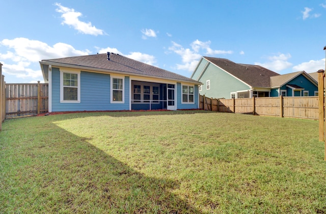 rear view of property featuring a sunroom and a yard