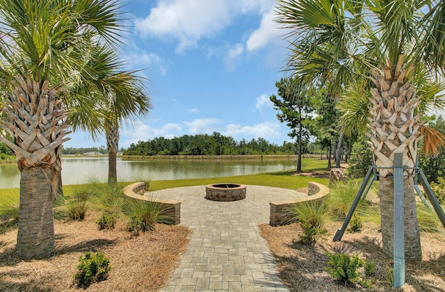 surrounding community with a water view and an outdoor fire pit