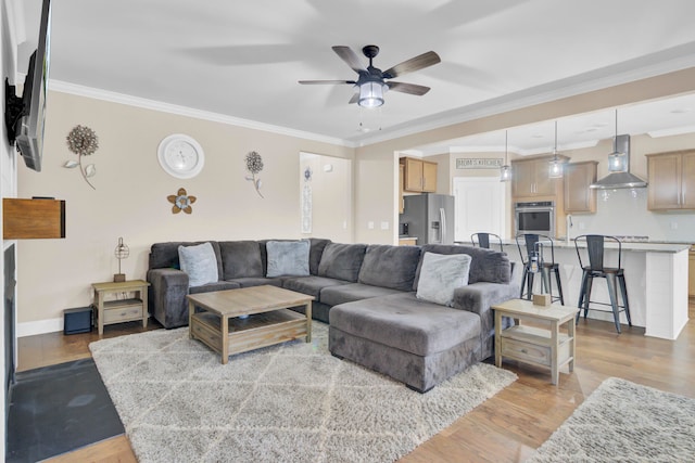 living room featuring ceiling fan, light hardwood / wood-style flooring, and ornamental molding