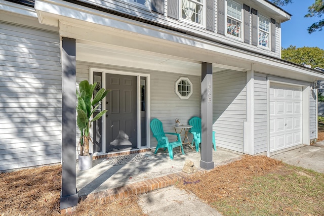 doorway to property featuring a porch and a garage