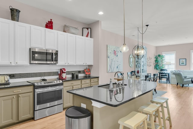 656 Coleman Blvd Unit 703, Mount Pleasant, SC 29464 - kitchen with appliances with stainless steel finishes, a sink, dark countertops, light wood-type flooring, and backsplash