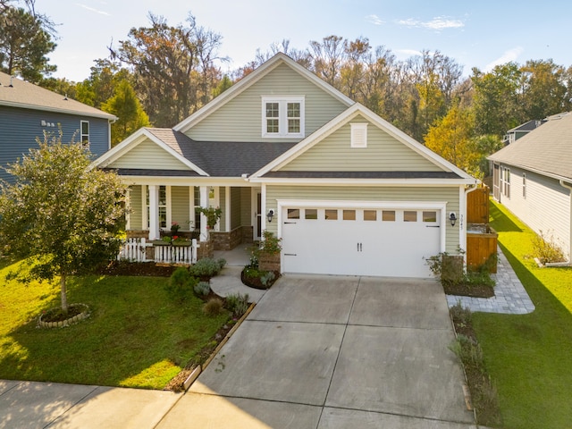 view of front of house with covered porch, a garage, and a front lawn