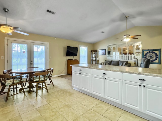 kitchen featuring french doors, white cabinetry, light tile patterned floors, vaulted ceiling, and ceiling fan