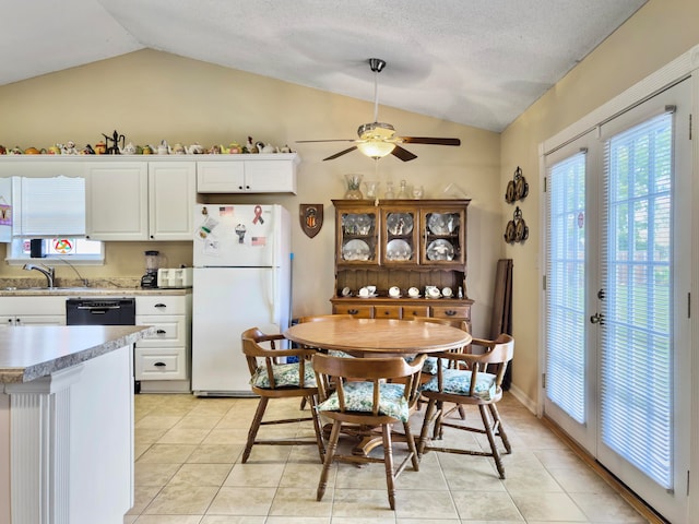 kitchen with white cabinetry, lofted ceiling, dishwasher, and white fridge