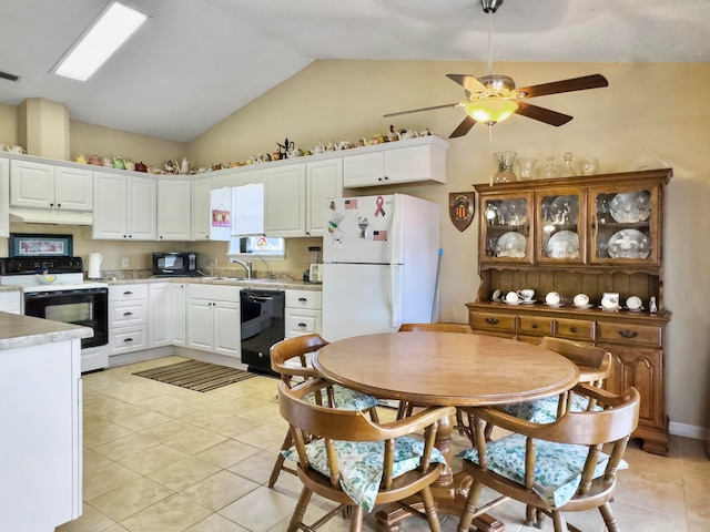 kitchen with vaulted ceiling, black appliances, sink, light tile patterned floors, and white cabinetry