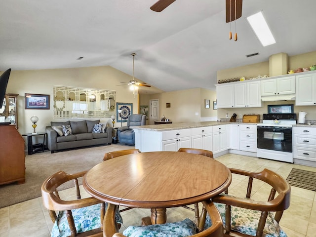 kitchen featuring vaulted ceiling, kitchen peninsula, light tile patterned floors, white cabinetry, and white range