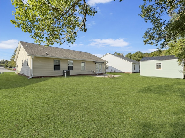 back of property with central AC unit and a lawn