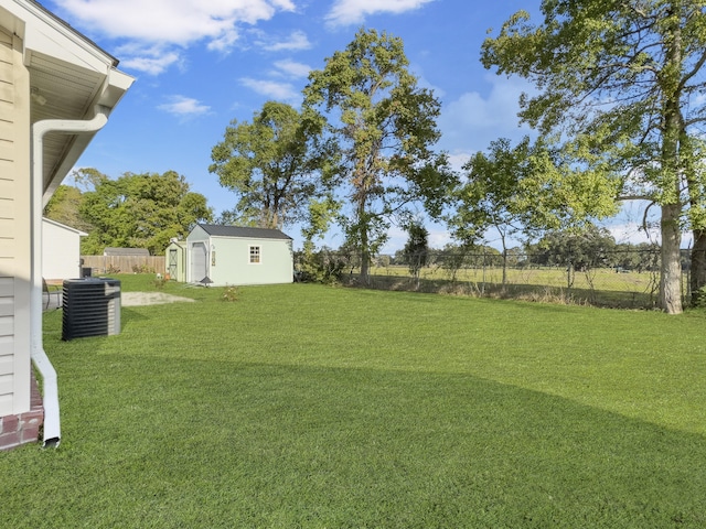 view of yard featuring a shed and central air condition unit