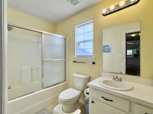 full bathroom featuring enclosed tub / shower combo, vanity, a textured ceiling, tile patterned flooring, and toilet