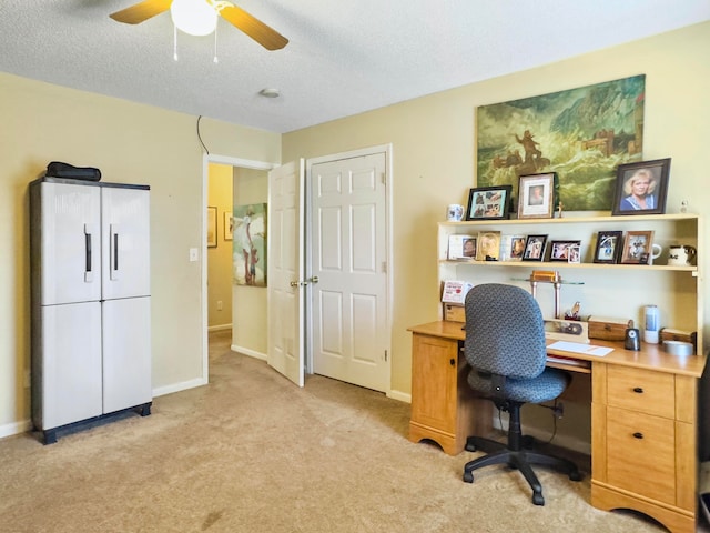 home office with a textured ceiling, light carpet, and ceiling fan