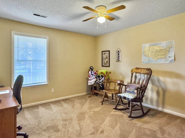 office with ceiling fan, a textured ceiling, and light carpet