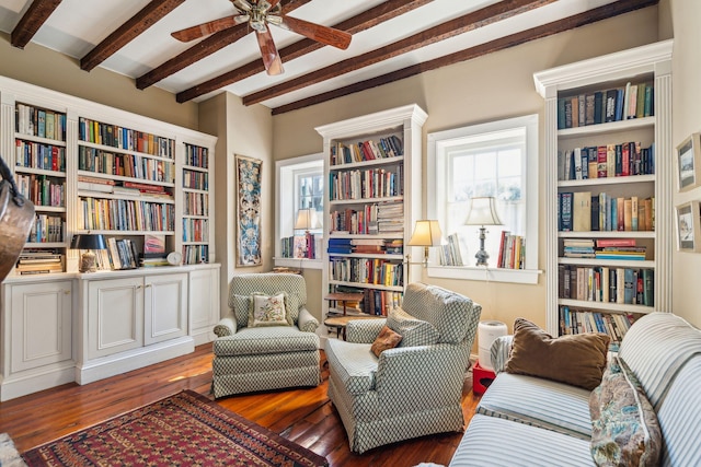 sitting room with ceiling fan, bookshelves, and hardwood / wood-style floors