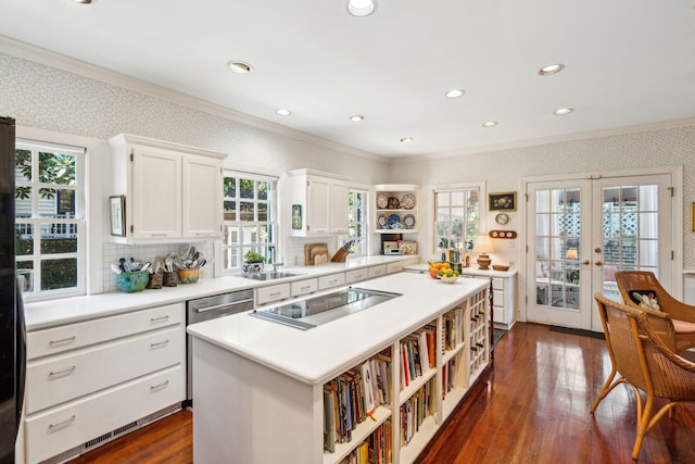 kitchen featuring ornamental molding, a kitchen island, white cabinetry, and wallpapered walls