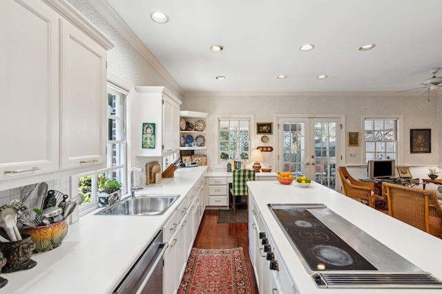 kitchen featuring french doors, white cabinets, a sink, and wallpapered walls