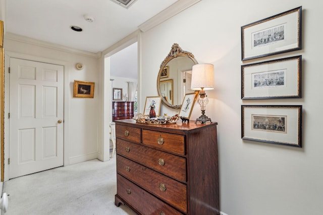 hall featuring ornamental molding, light colored carpet, and baseboards